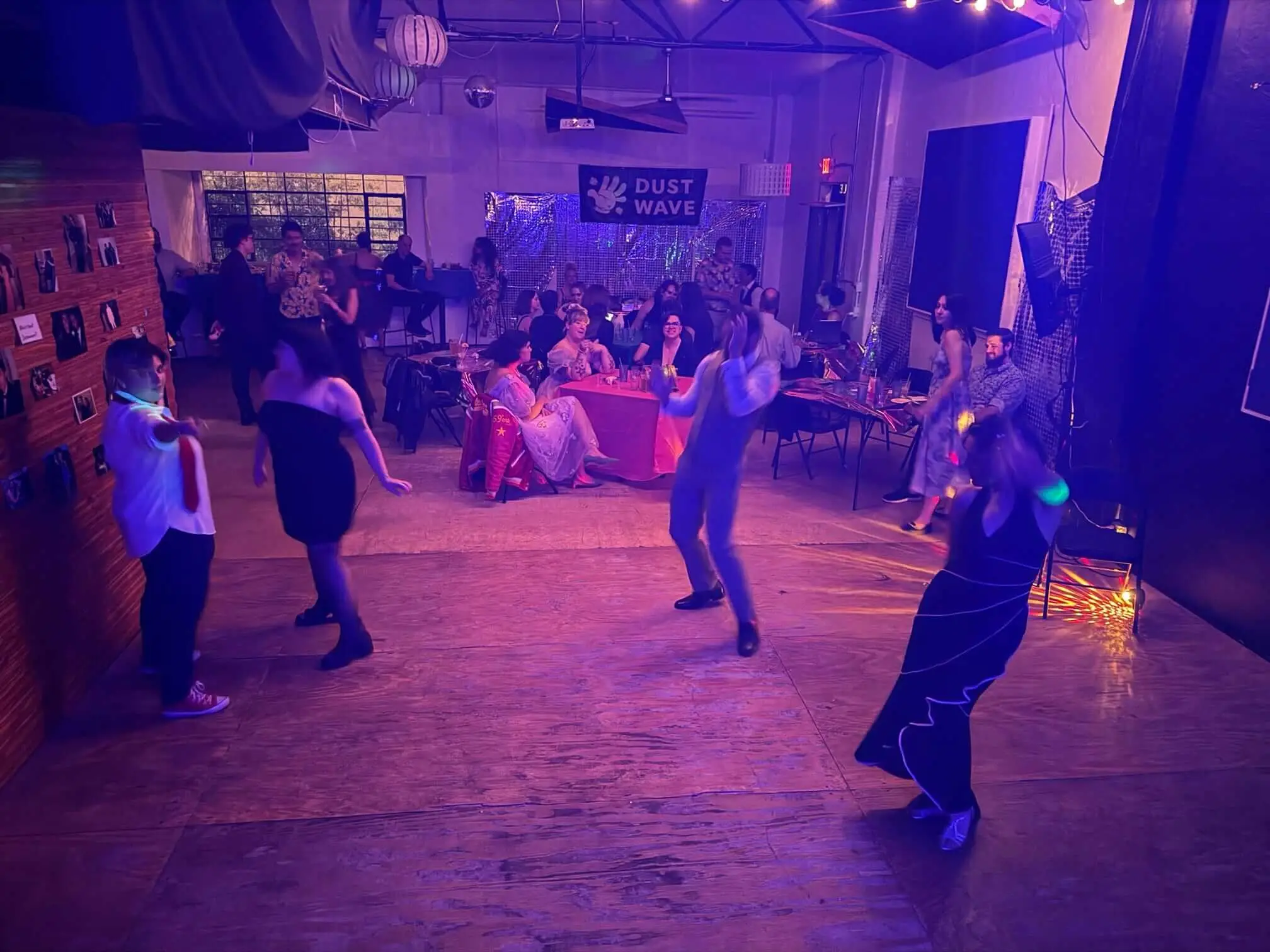 Guests dance beneath purple lights at Juno Brewery