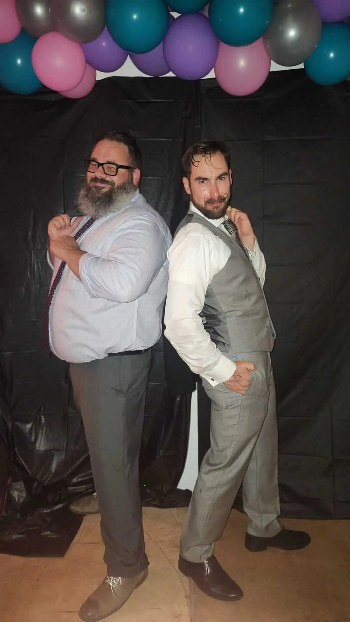 Two Dancewave guests pose back-to-back in formalwear
