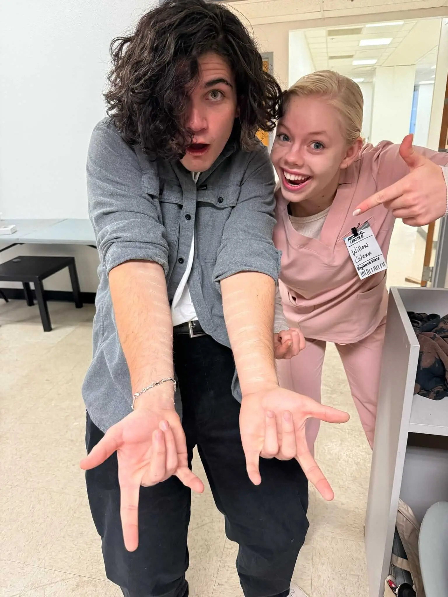 Two performers pose playfully between takes