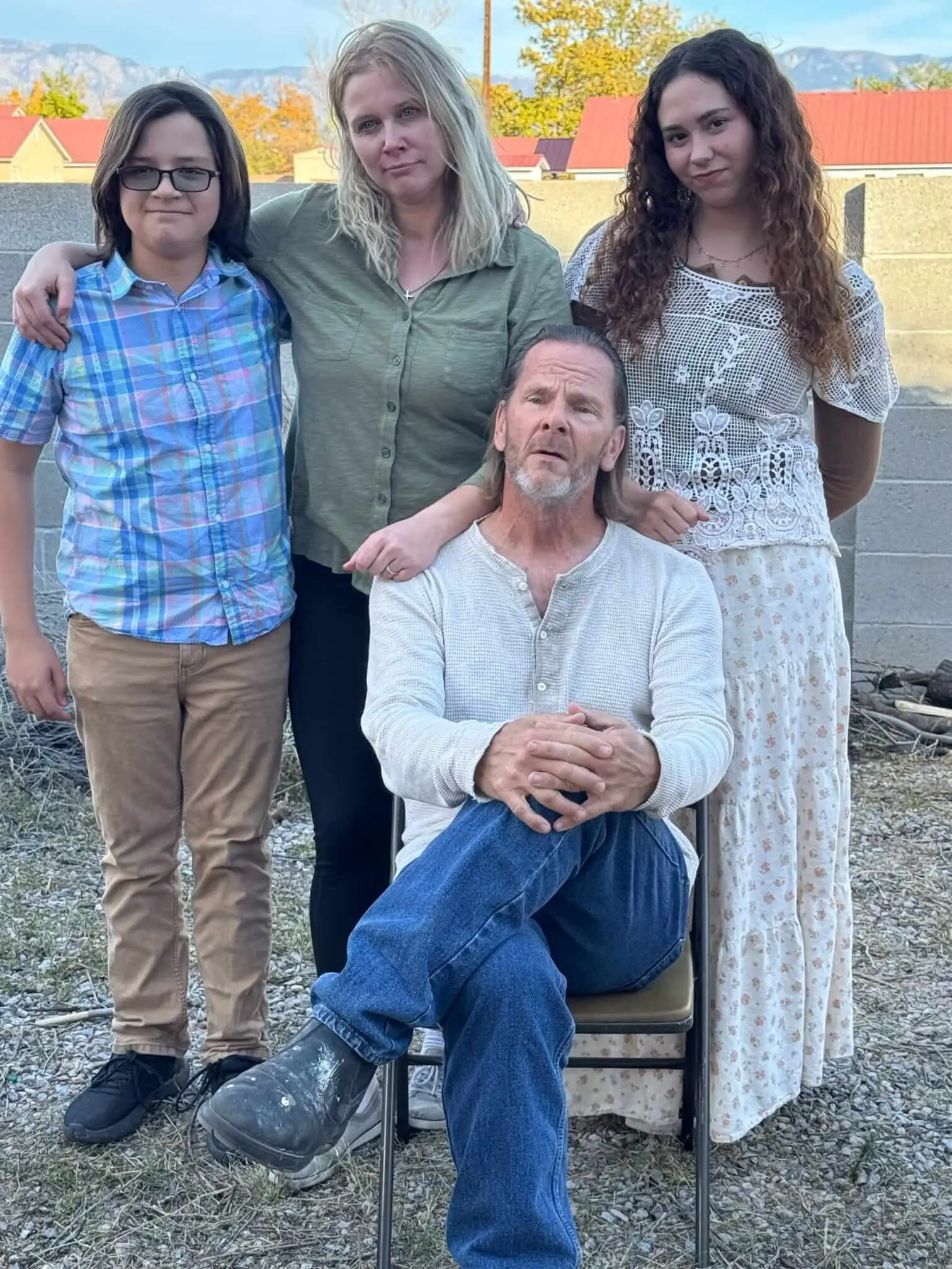 Four cast members pose together outdoors