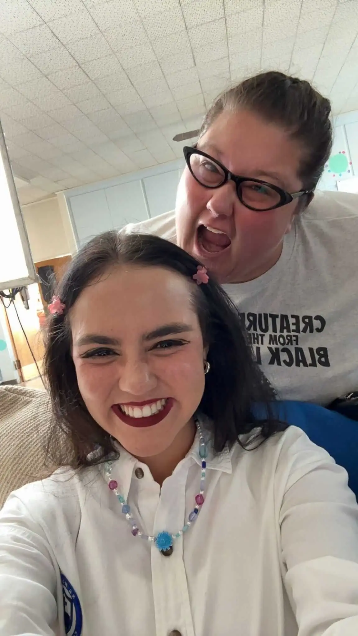Two cast and crew members take a smiling selfie on set