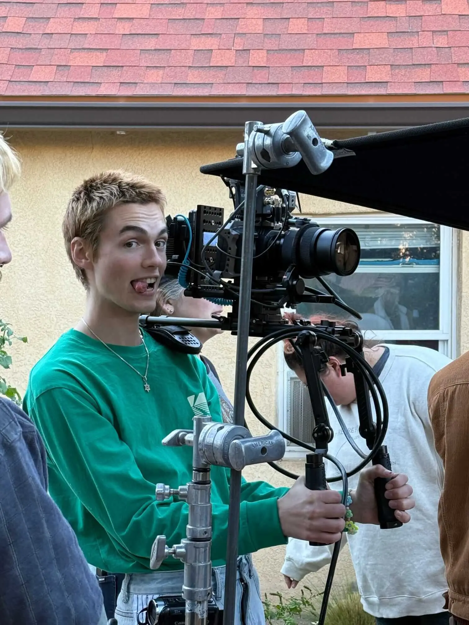 A camera operator poses beside a cinema camera rig